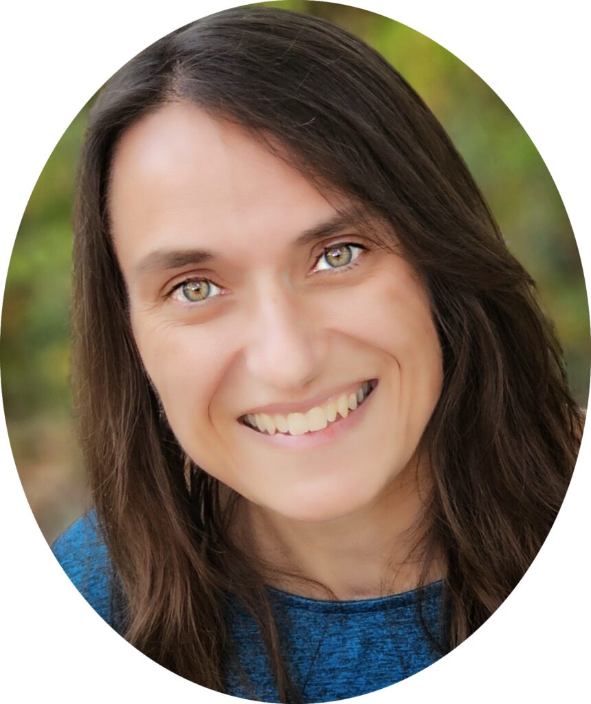 Close-up headshot of a middle-aged woman with dark brown hair and hazel eyes. She is wearing a blue-colored shirt.